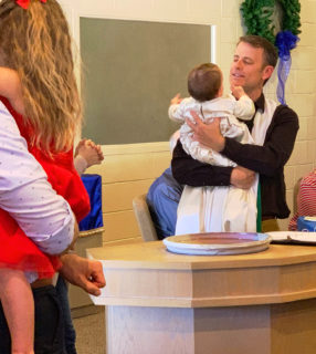 Pastor John performing a baptism for family members photo
