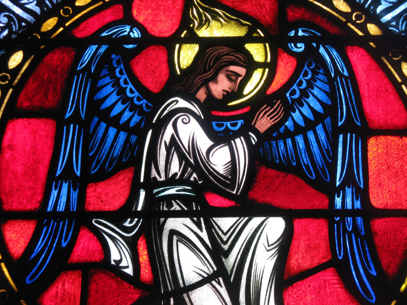 Stained Glass Window of an Angel praying to God.