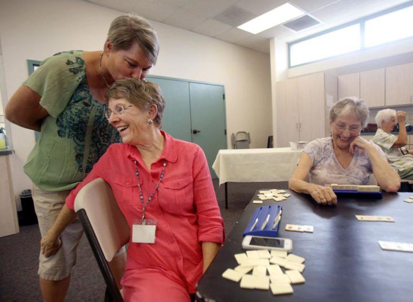 Mary Kay Bush gets a kiss from daughter Cheryl Minarik Baril during a weekly game of Rummy Cubes at Immanuel Presbyterian Church, Tucson, Arizona..